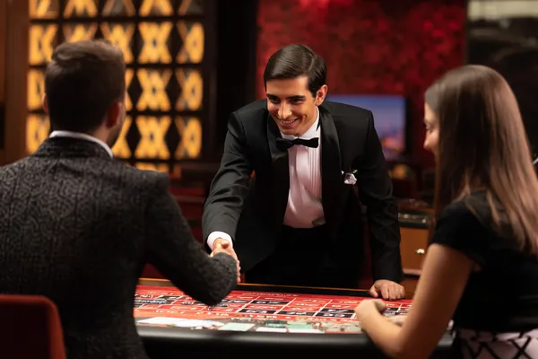A woman in a luxurious green gown next to an ornate roulette wheel, capturing the upscale casino mood of BA99.